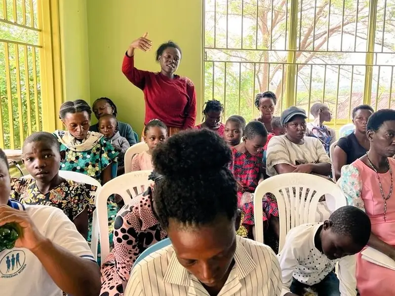 Young participants seated in plastic chairs during an indoor workshop