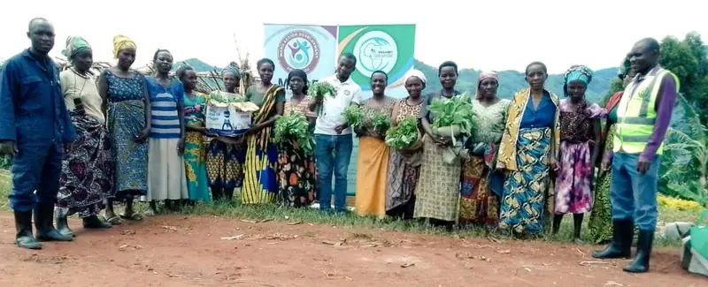 Women farmers and Maru Foundation staff gather for a group photo at a backyard garden