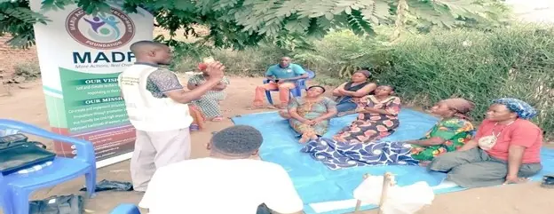 Women sit on mats during a savings group mentorship session