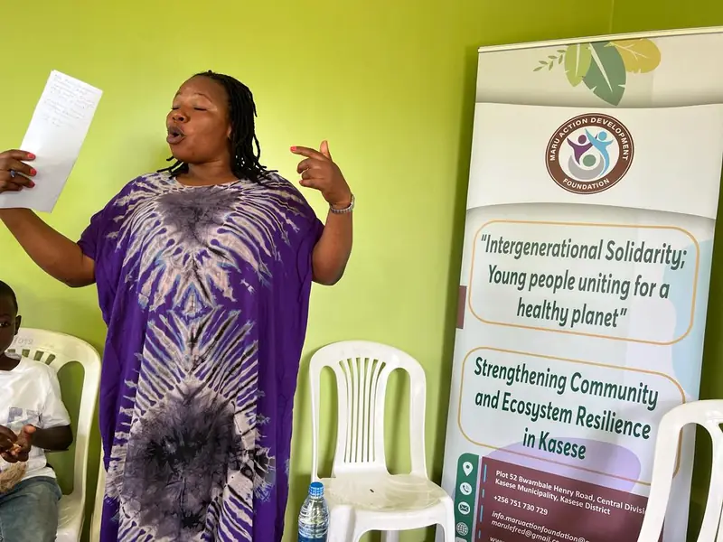 A woman speaks to a workshop beside banners reading Intergenerational Solidarity