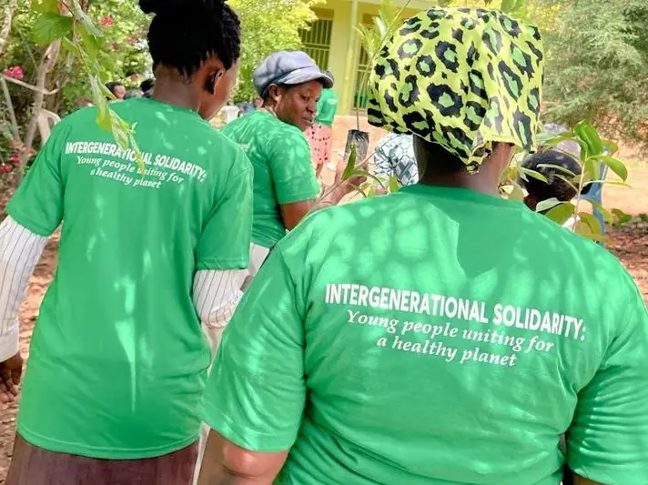 Volunteers in green shirts reading Intergenerational Solidarity, young people uniting for a healthy planet