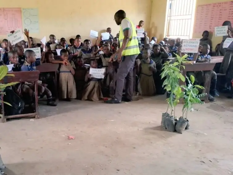 A facilitator speaks to pupils in a classroom about tree planting