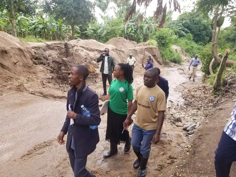 Team members walk along a flood-eroded riverbed assessing the damage