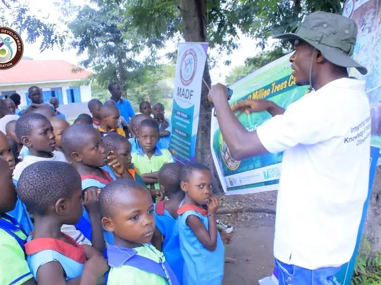 A facilitator talks to young pupils about a plant-based diet poster