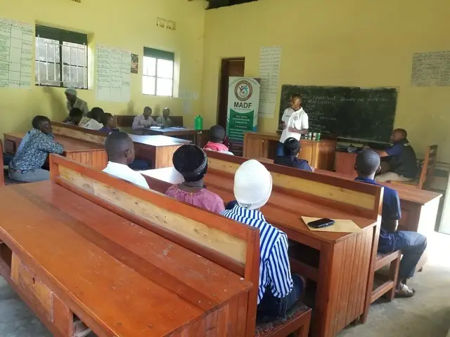 Participants sit on benches in a classroom during a Seeds of Resilience school session